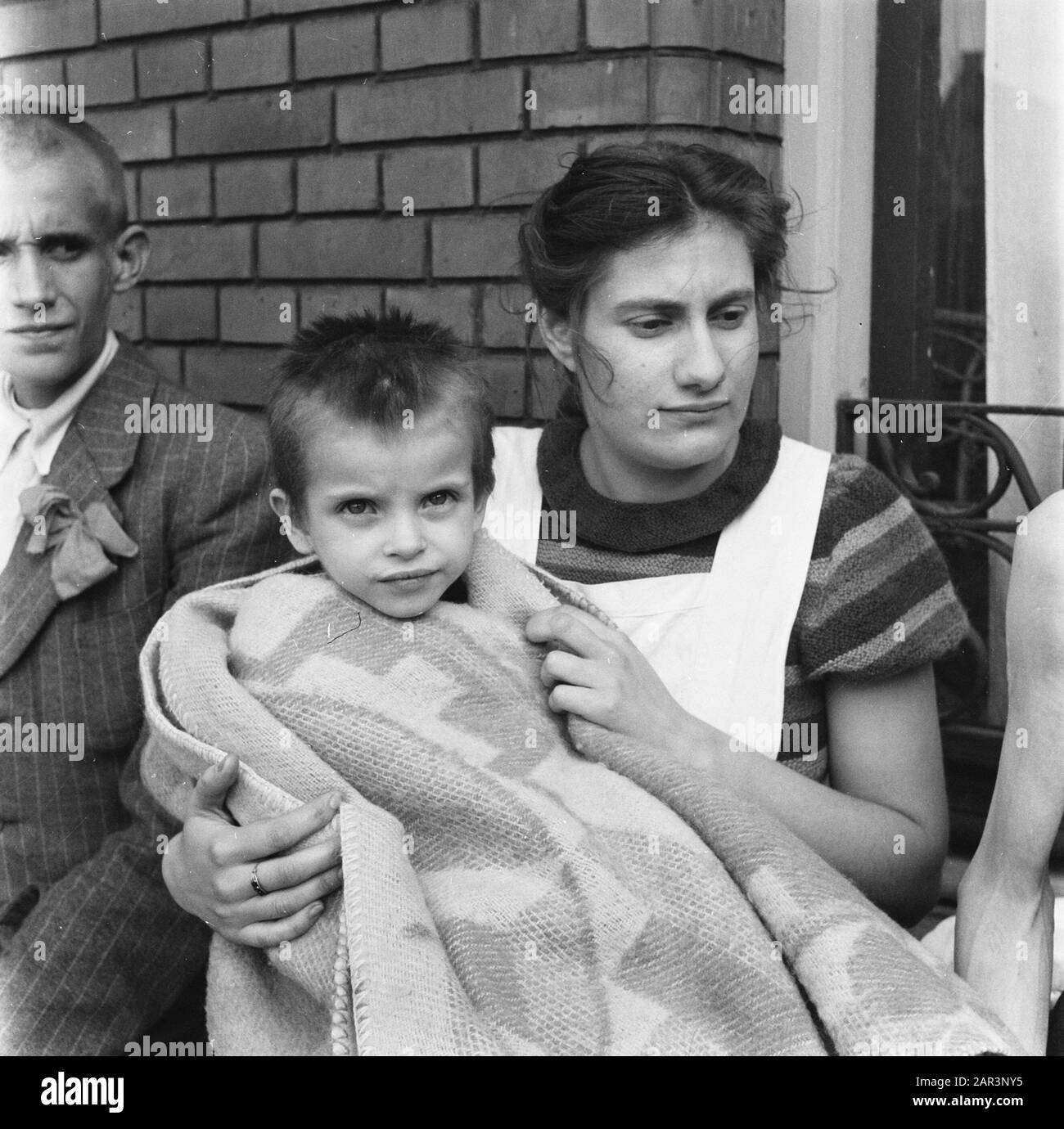 Child care of the Red Cross  Child wrapped in blanket with caregiver Date: 1945 Keywords: Red Cross, World War II Stock Photo