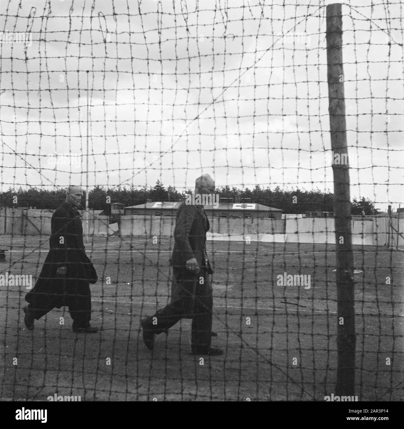 Camp Amersfoort, internment camp for war criminals and collaborators  [Two men behind a high fence of barbed wire] Date: 1945 Location: Amersfoort Keywords: Purification, World War II Stock Photo