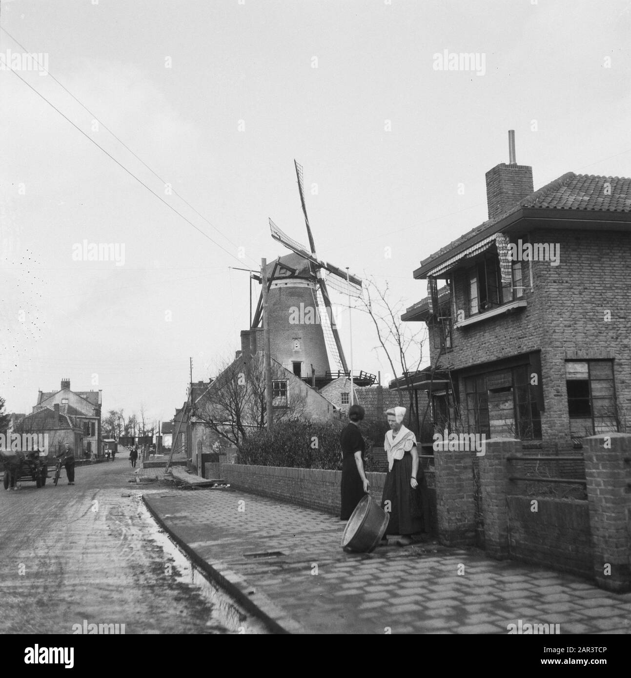 Walcheren: Herstelling Nollegat in the seawall and other places in Walcheren  Kanaalstraat in Oost-Souburg. Doctor's house with mill. Date: 1945 Location: Oost-Souburg, Zeeland Keywords: buildings, repairs, mill, destruction, reconstruction Stock Photo
