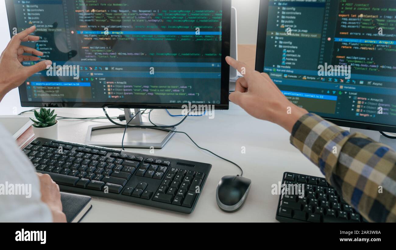 Young startup Programmers Sitting At Desks Working On Computers screen for Developing programming and coding to find solution to problem on New Applic Stock Photo