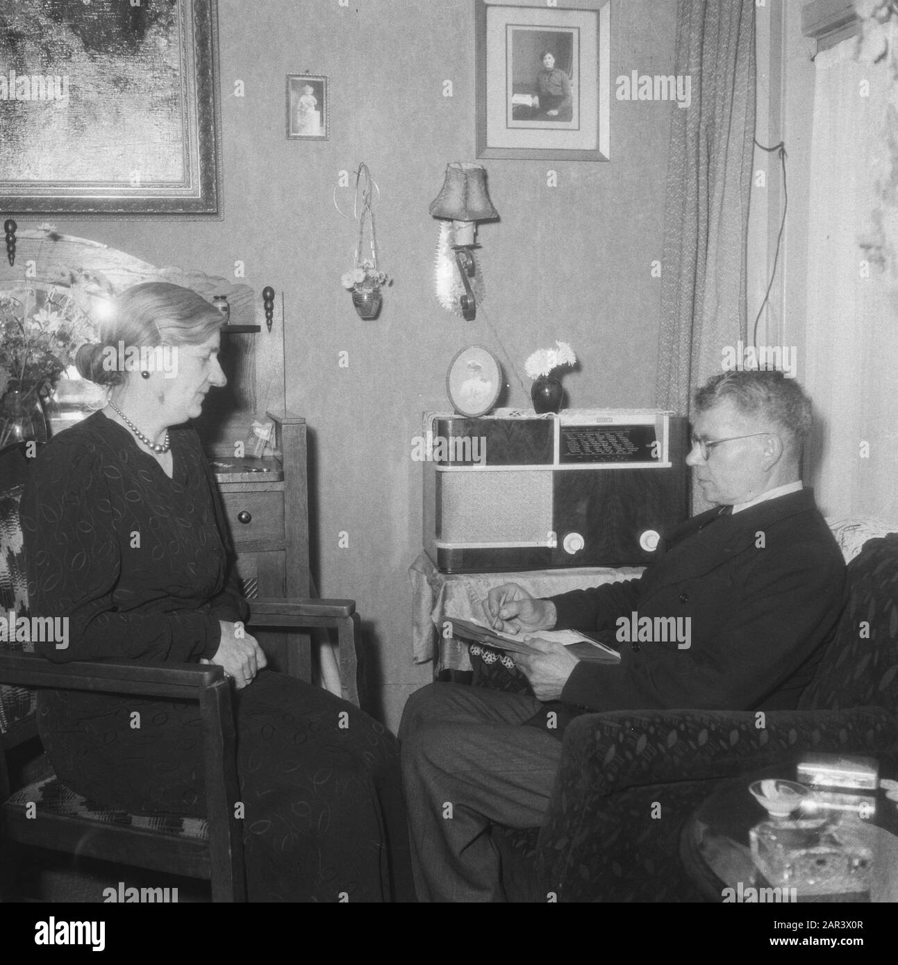 Rising Netherlands  Reportage Rising Netherlands Annotation: Couple listens to the radio Date: November 2, 1945 Location: Eindhoven Keywords: radio, information Institution name: Radio Rising Netherlands Stock Photo