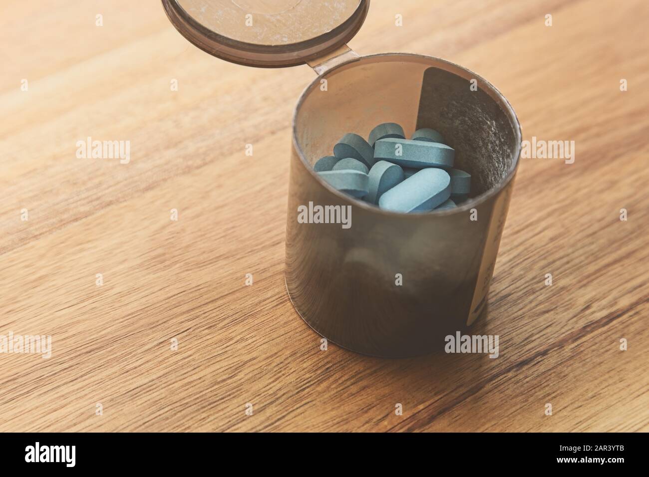 Download A High Angle Shot Of A Container Of Blue Pills On A Wooden Surface Stock Photo Alamy Yellowimages Mockups