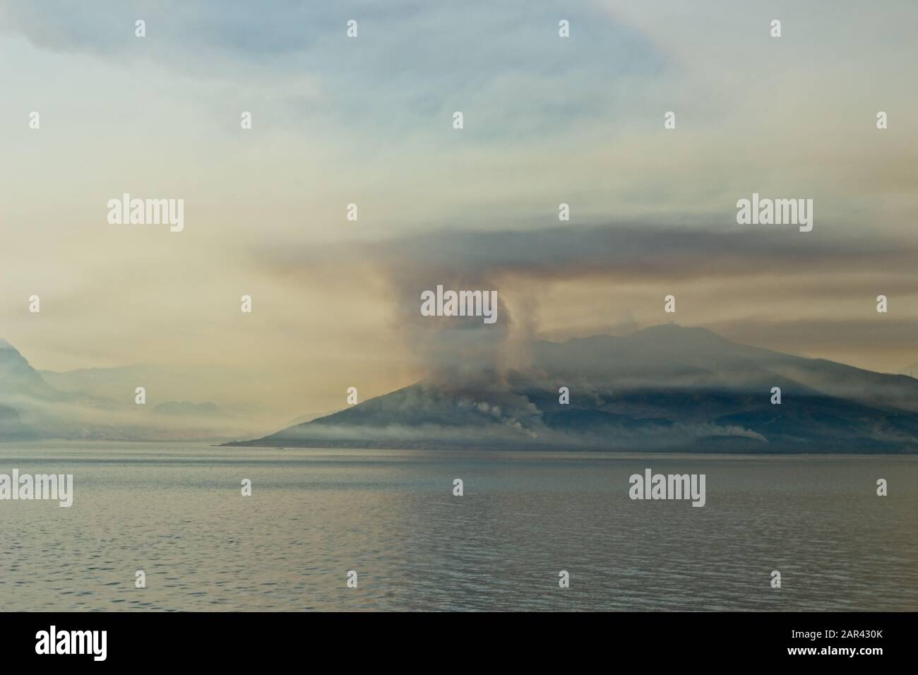 Scenery of smoke coming out of the mountain at the ocean Stock Photo