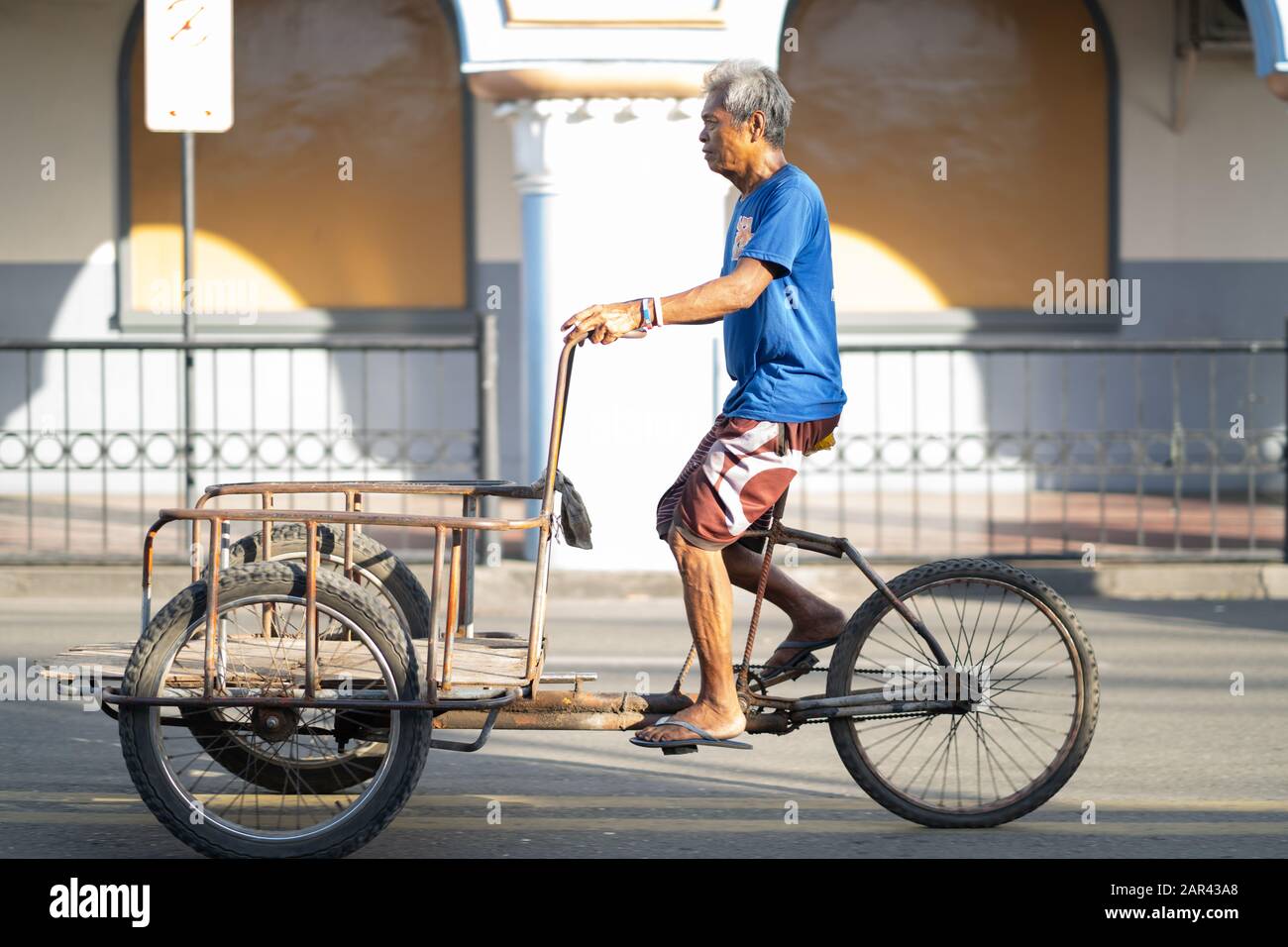 A man pedals an improvised tricycle within a market area of Cebu City,Philippines Stock Photo