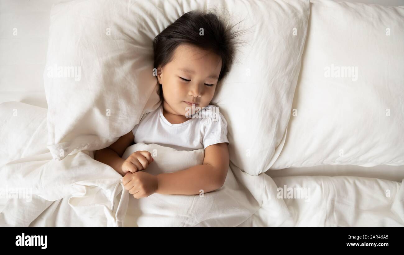 Cute little Asian girl relax sleeping in bed Stock Photo