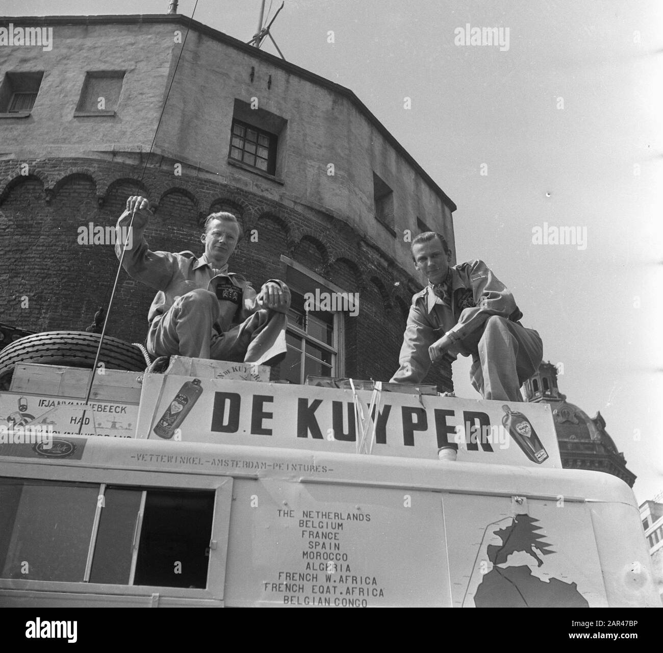 Departure Cape Town Expedition from Amsterdam. Dromedaris II with the trader Karei Kramer (25) behind the wheel and car technician Jan Helms (28), head through the roof of the jungle truck, on the lookout, started exactly a quarter past eleven from the Prince Hendrikkade for their adventurous and commercial journey of 3 March to the Union of South - Africa. Annotation: In the footsteps of Van Riebeeck HOLLAND BOYS TO THE CAPE. The Telegraph. Amsterdam, 15-05-1952. Seen on Delpher on 12-05-2017, resolver.kb.en/ resolve?urn=ddd:110585505:mpeg21:a0120 Date: 14 May 1952 Keywords: expeditions Stock Photo