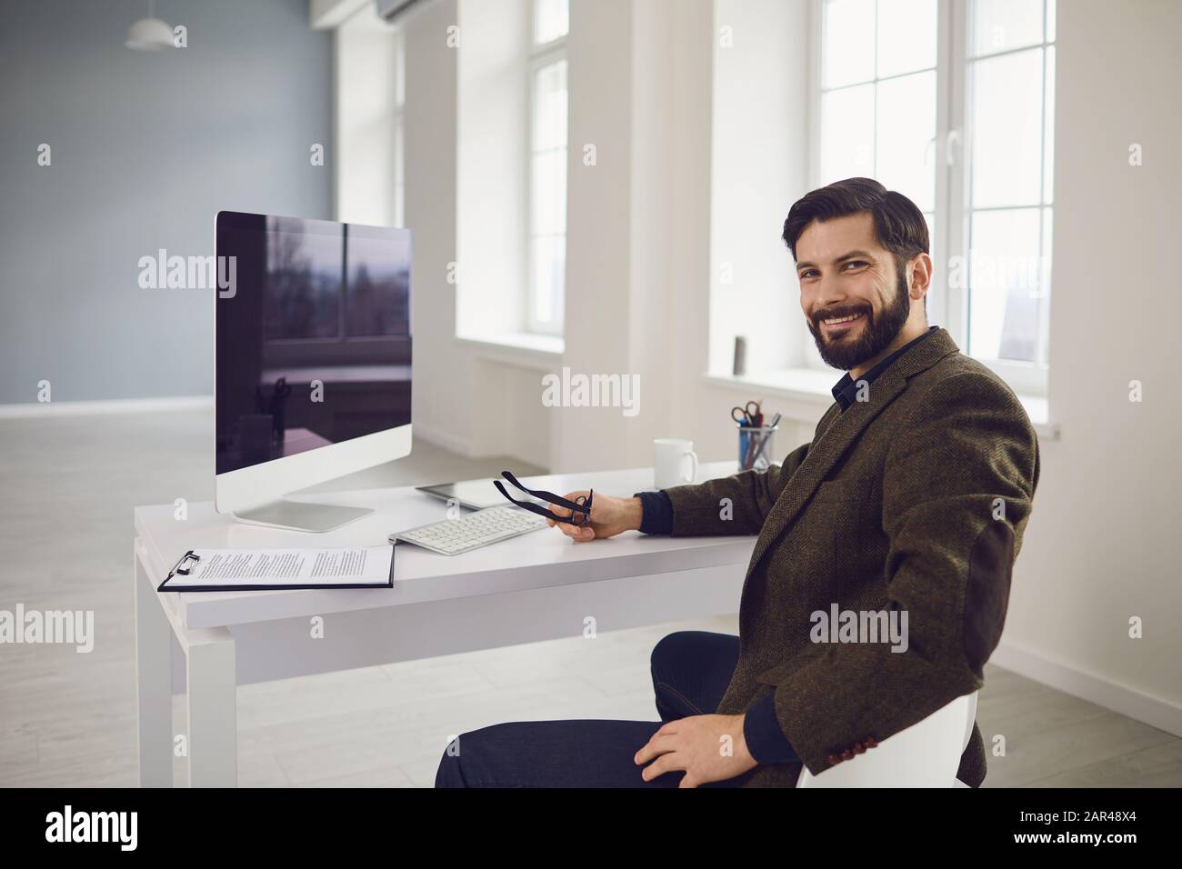 Businessman works at the computer at the table in the workplace in the office Stock Photo