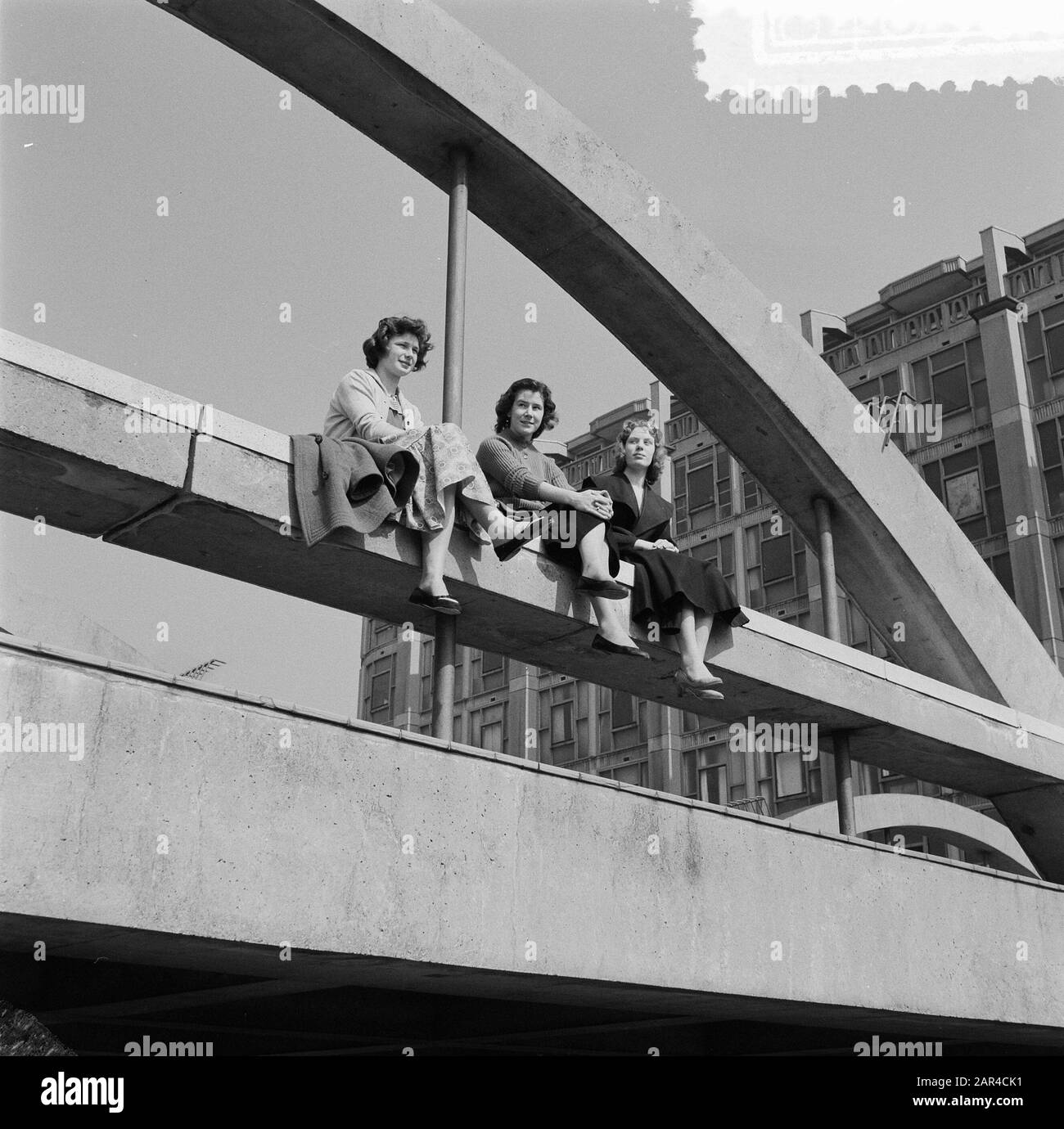 Girls enjoying the sun on driveway Groothandelsgebouw Rotterdam Annotation: The architects are Huig A. Maaskant and Willem van Tijen Date: 7 april 1957 Location: Rotterdam, Zuid-Holland Keywords: girls, sun Stock Photo