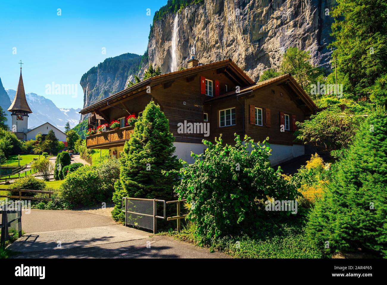 Stunning charming alpine village with high waterfalls and idyllic church. Wonderful travel and touristic destination, Lauterbrunnen village with Staub Stock Photo