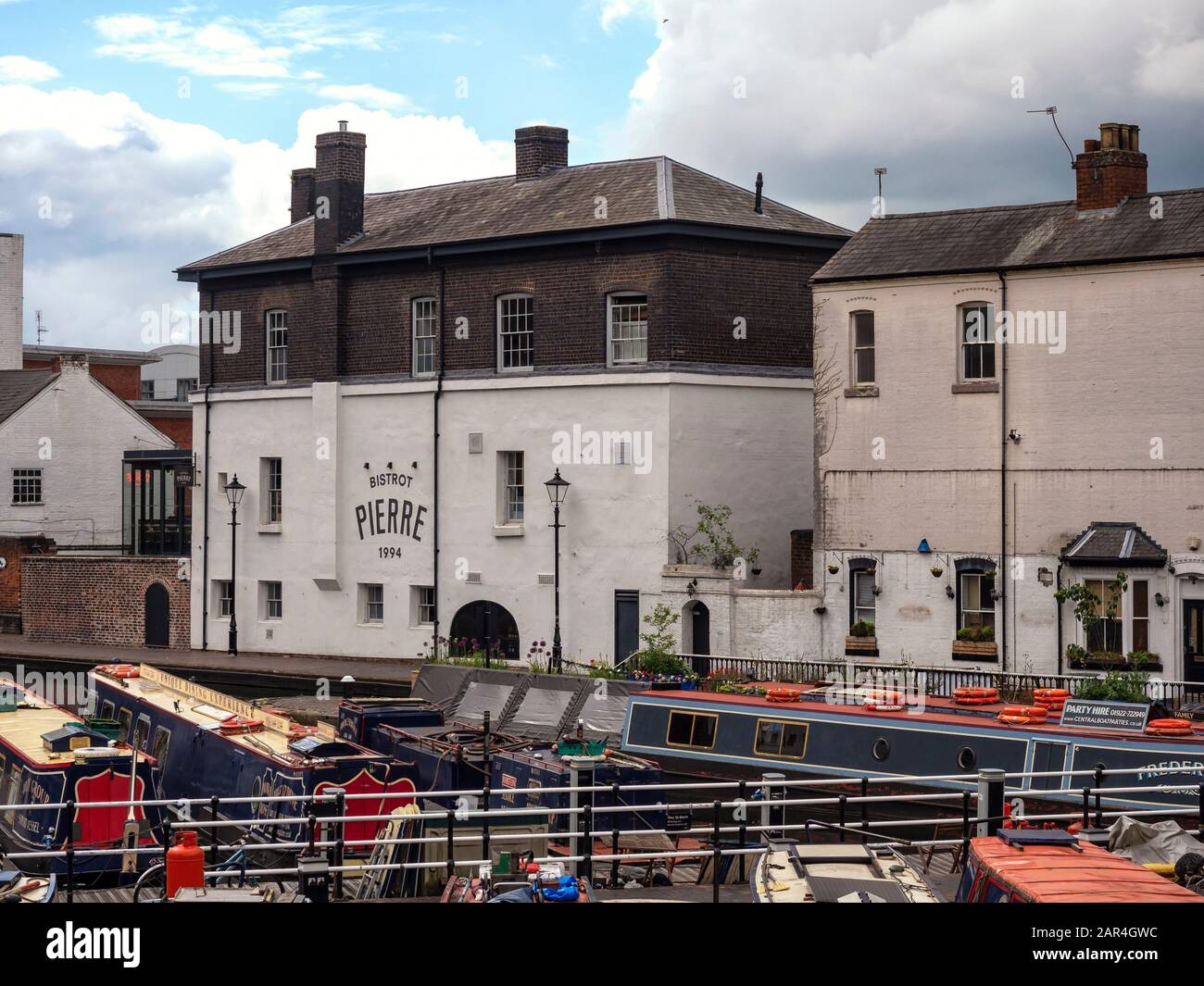 BIRMINGHAM, UK - MAY 28, 2019:  View of Bistrot Pierre over narrowboats moored on the canal at Brindley Place. Stock Photo