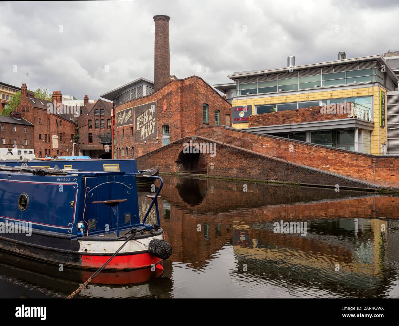 BIRMINGHAM, UK -MAY 28, 2019:  Narrowboat on the canal at Brindley Place surrounded by restored Victorian building and modern office buildings Stock Photo