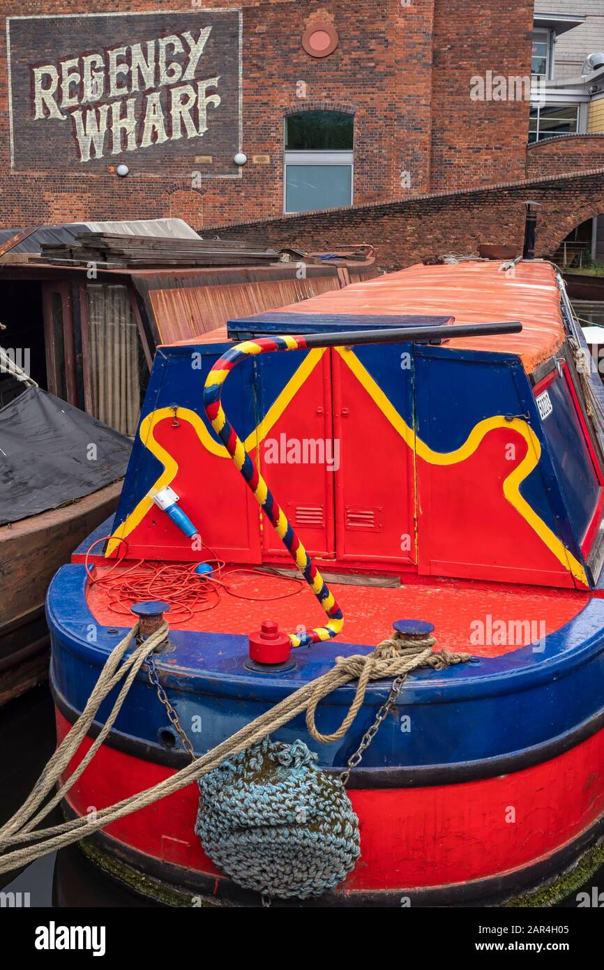 BIRMINGHAM, UK - MAY 28, 2019:  Brightly painted narrowboat on the canal at Brindley Place moored in front of the victorian Regency Wharf Stock Photo