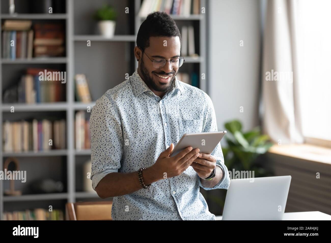 Smiling african business man using digital tablet computer in office Stock Photo