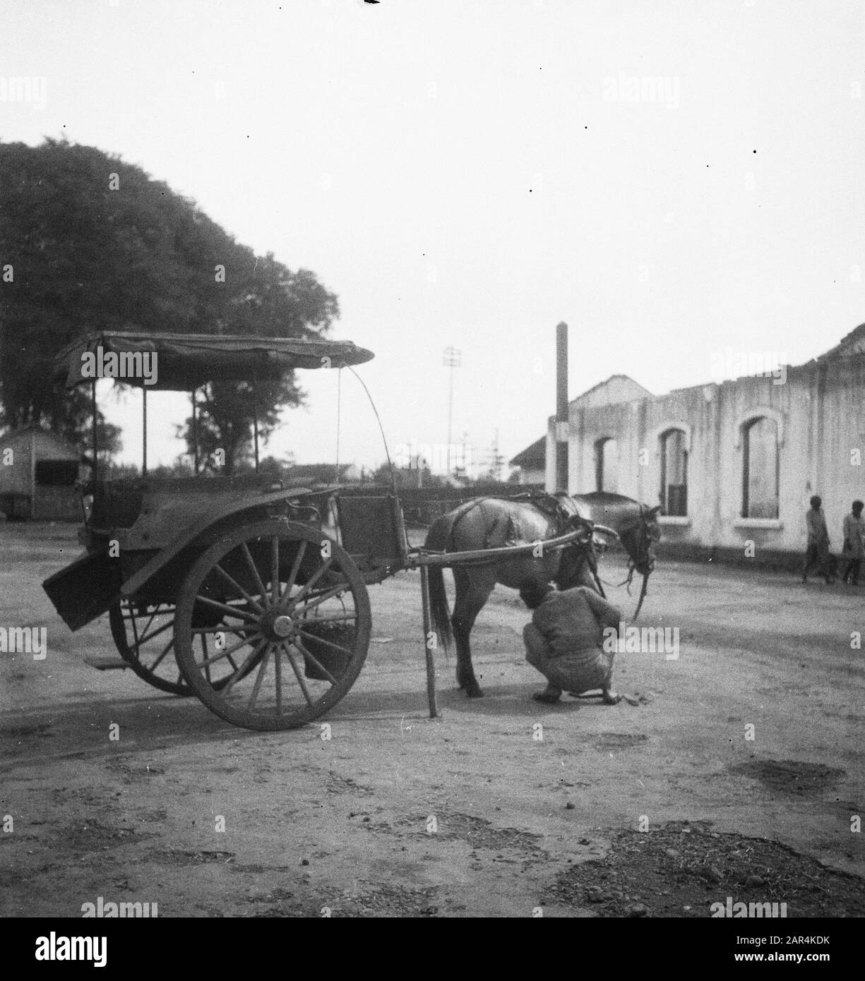 Magelang en surroundings  [a Dokar (horse and wagon) is standing on the street near a burned-out building] Date: February 13, 1949 Location: Indonesia, Dutch East Indies Stock Photo