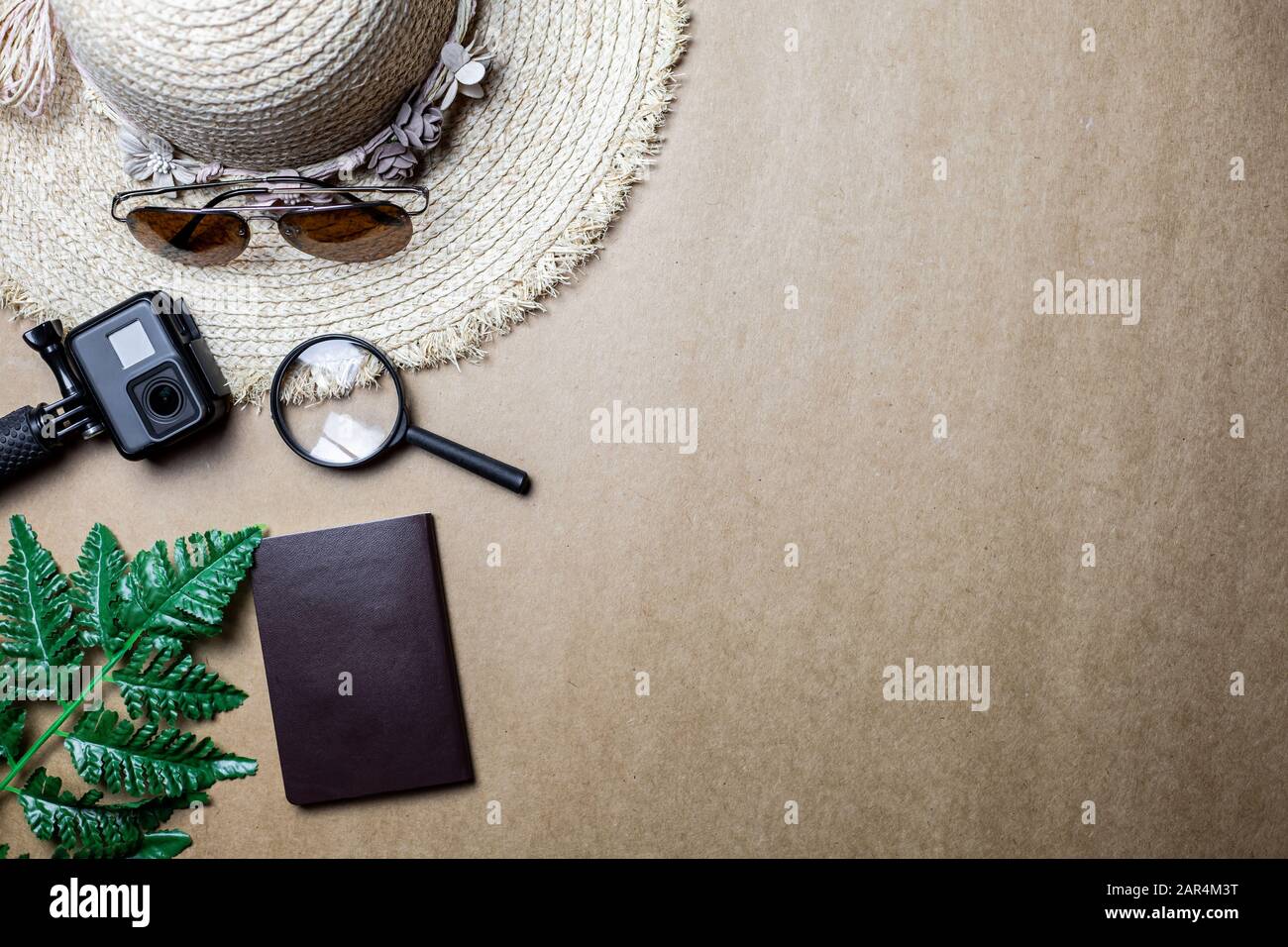 Top view of accessories used for leisure travelers on a brown background. Travel accessories and copy space. Concept of top view travel accessories. Stock Photo