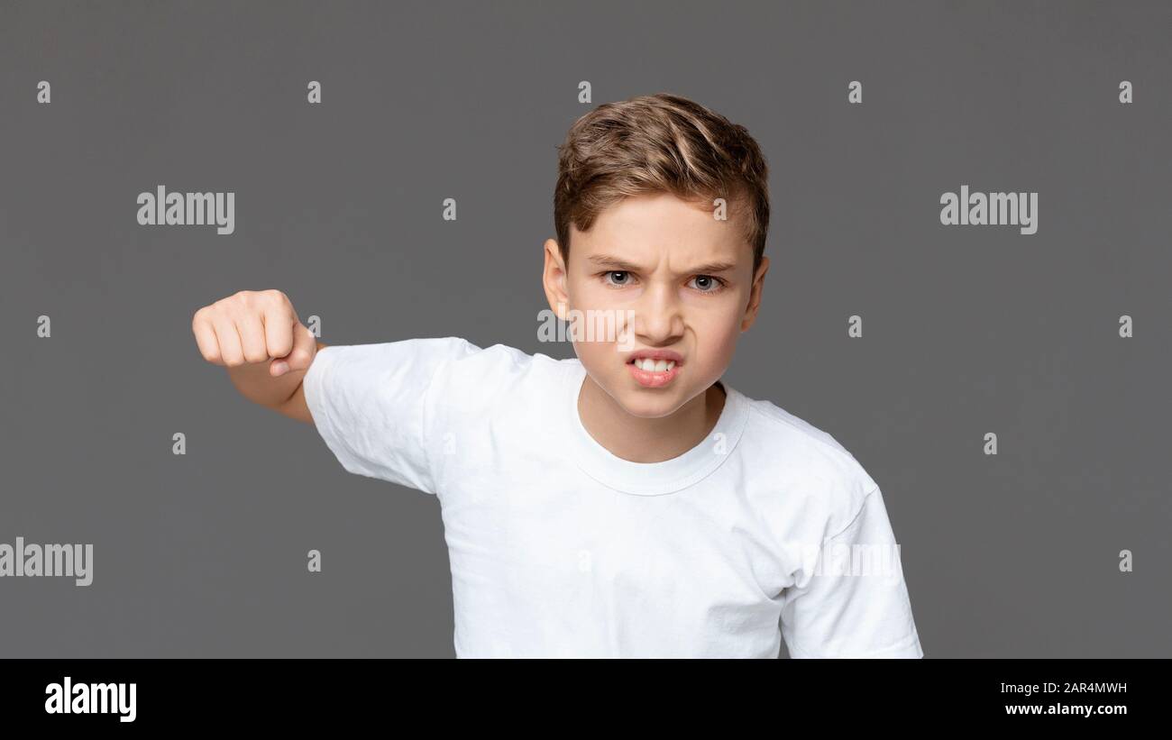 Furious teenager punching at camera with angry expression Stock Photo