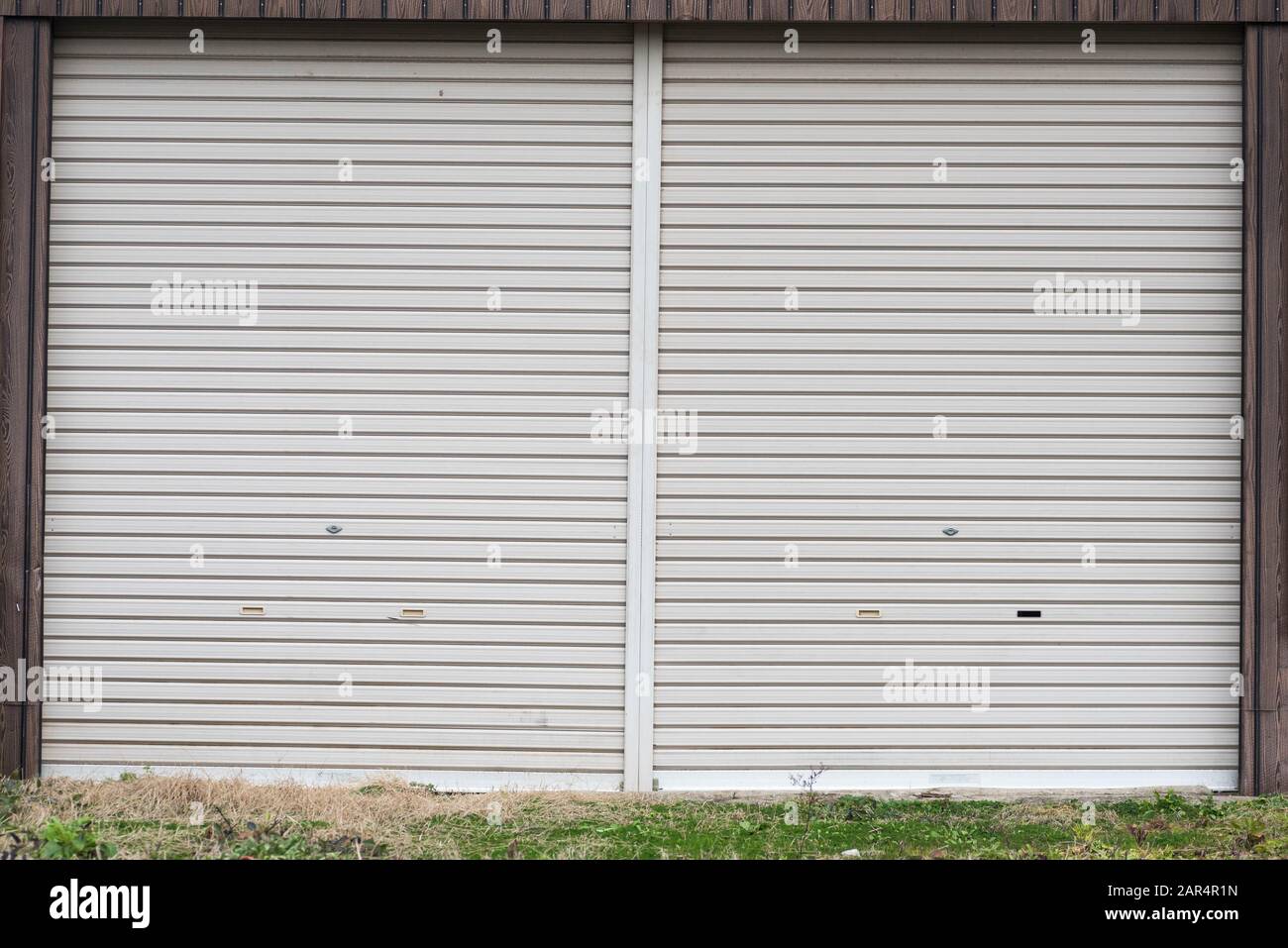 An old metal roller shutter at a closed store front. Stock Photo