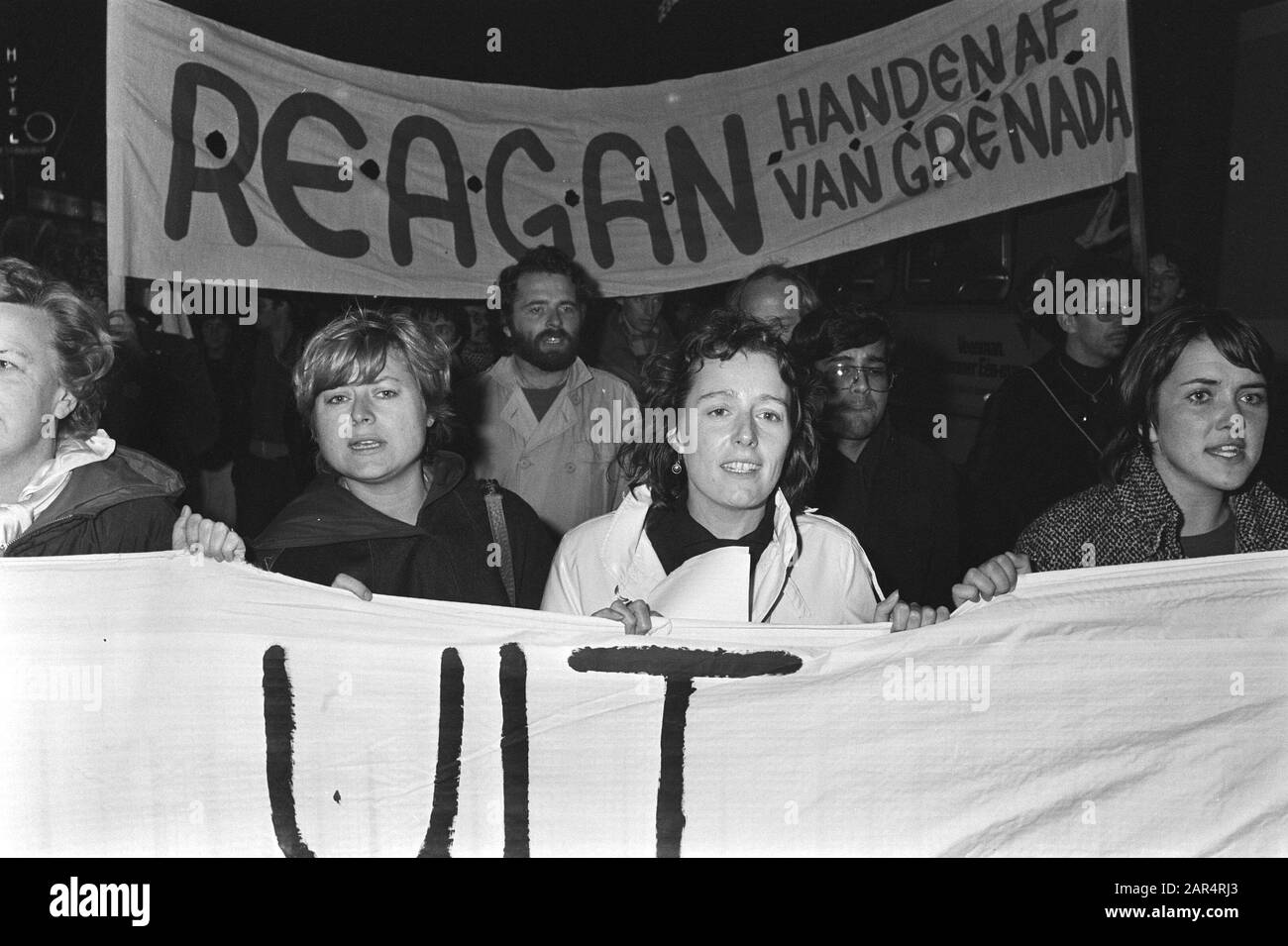 Demonstration in Amsterdam against the invasion by the US in Grenada after a coup  Eveline Herfkens (PvdA) (l) and Ina Brouwer (CPN) Annotation: Behind them a banner Reagan hands off of Grenada Date: 25 October 1983 Location: Amsterdam, Noord-Holland Keywords: demonstrations, military operations, parades, parliamentarians, banners Personal name: Brouwer, Ina, Herfkens, Eveline Stock Photo