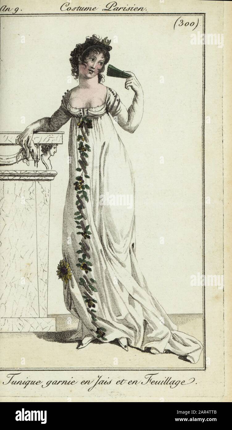 Fashionable woman or Merveilleuse in low-cut tunic dress, 1801. Her dress is decorated with jet and foliage. She leans on a mantlepiece and holds a fan. Tunique garnie en Jais et en Feuillage. Handcoloured copperplate engraving from Pierre de la Mesangere’s Journal des Modes et Dames, Paris, 1801. The illustrations in volume 4 were by Carle Vernet, Bosio, Dutailly and Philibert Louis Debucourt. Stock Photo