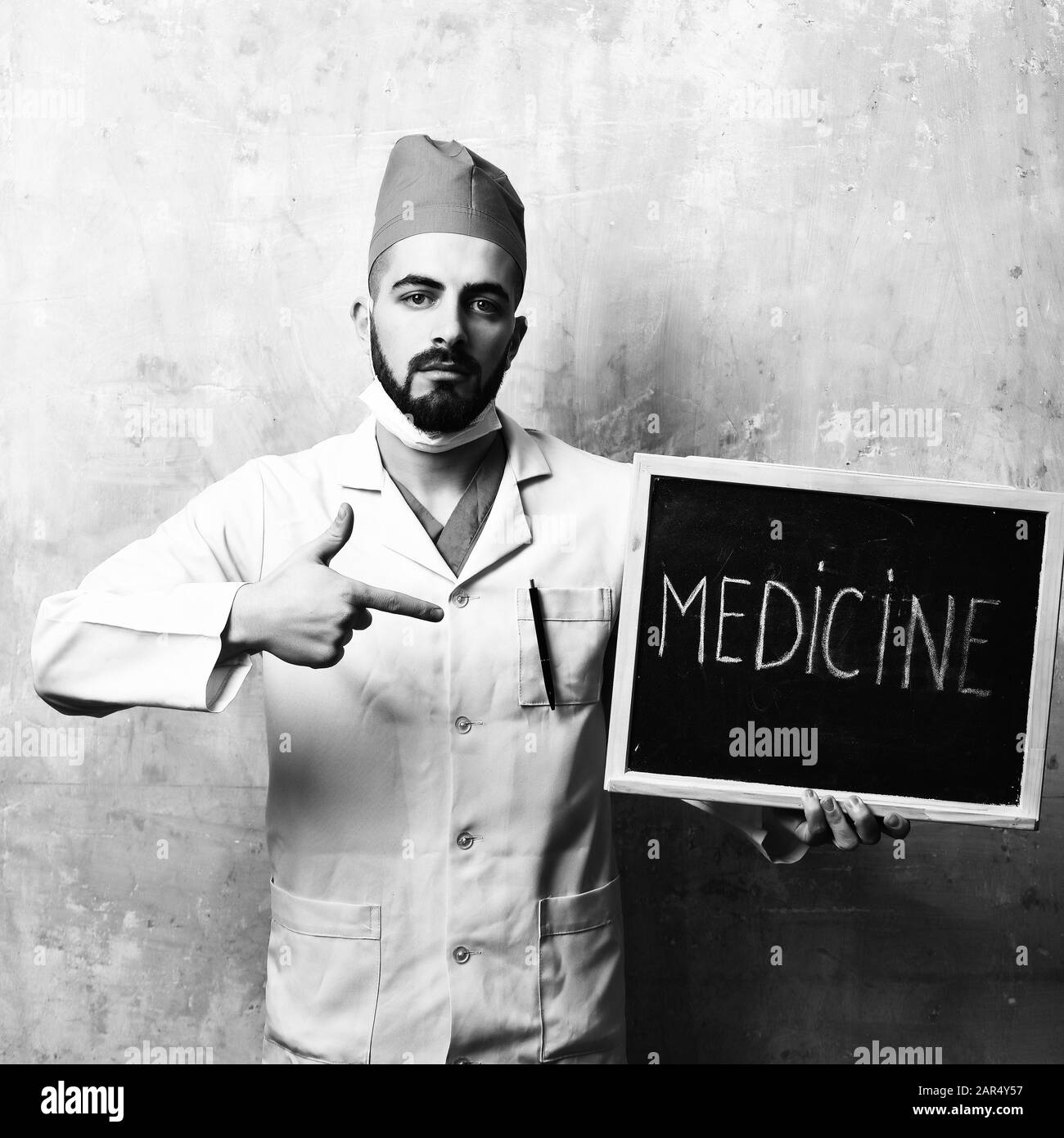 Doctor With Beard Pointing At Little Blackboard With Word Medicine