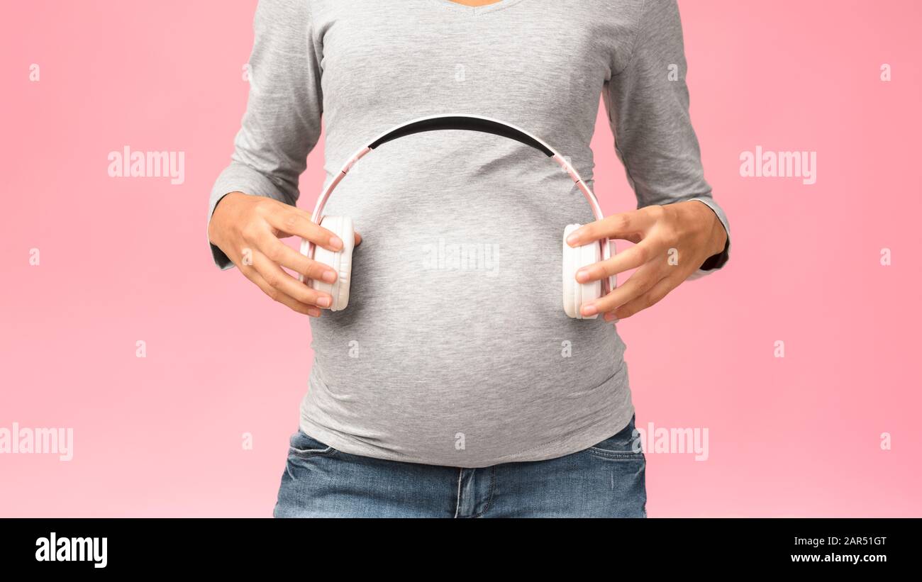 Music and pregnancy. Expectant woman holding headphones near belly Stock  Photo - Alamy