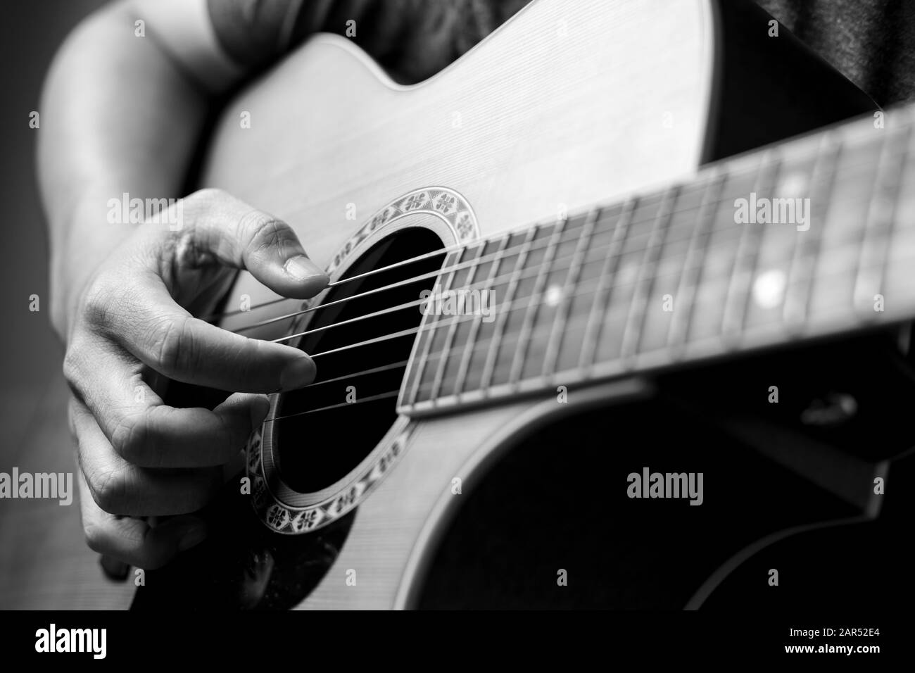 Male musicians playing acoustic guitar. Closeup musicians are playing acoustic guitar. Male musicians hold chords and strum guitar. Stock Photo
