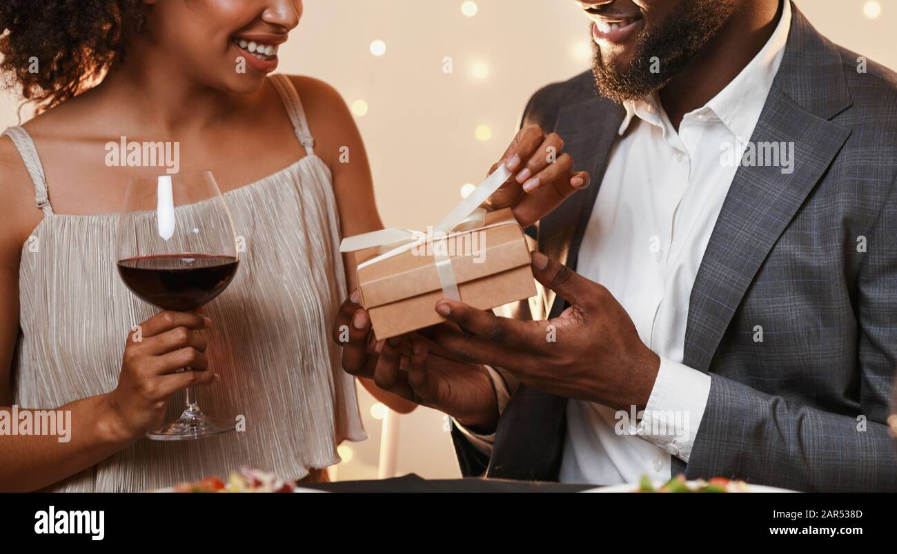 Charming afro man giving present to his woman Stock Photo