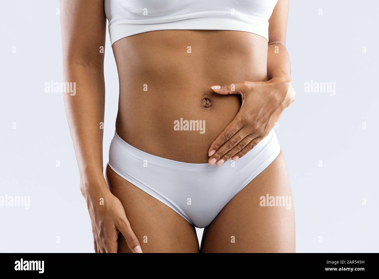 Cropped of black woman in underwear holding hand on belly Stock Photo by  Prostock-studio