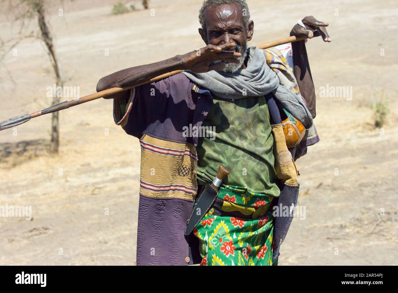 Ethiopian shepherd walking in the Afar landscape, Ethiopia. The ...