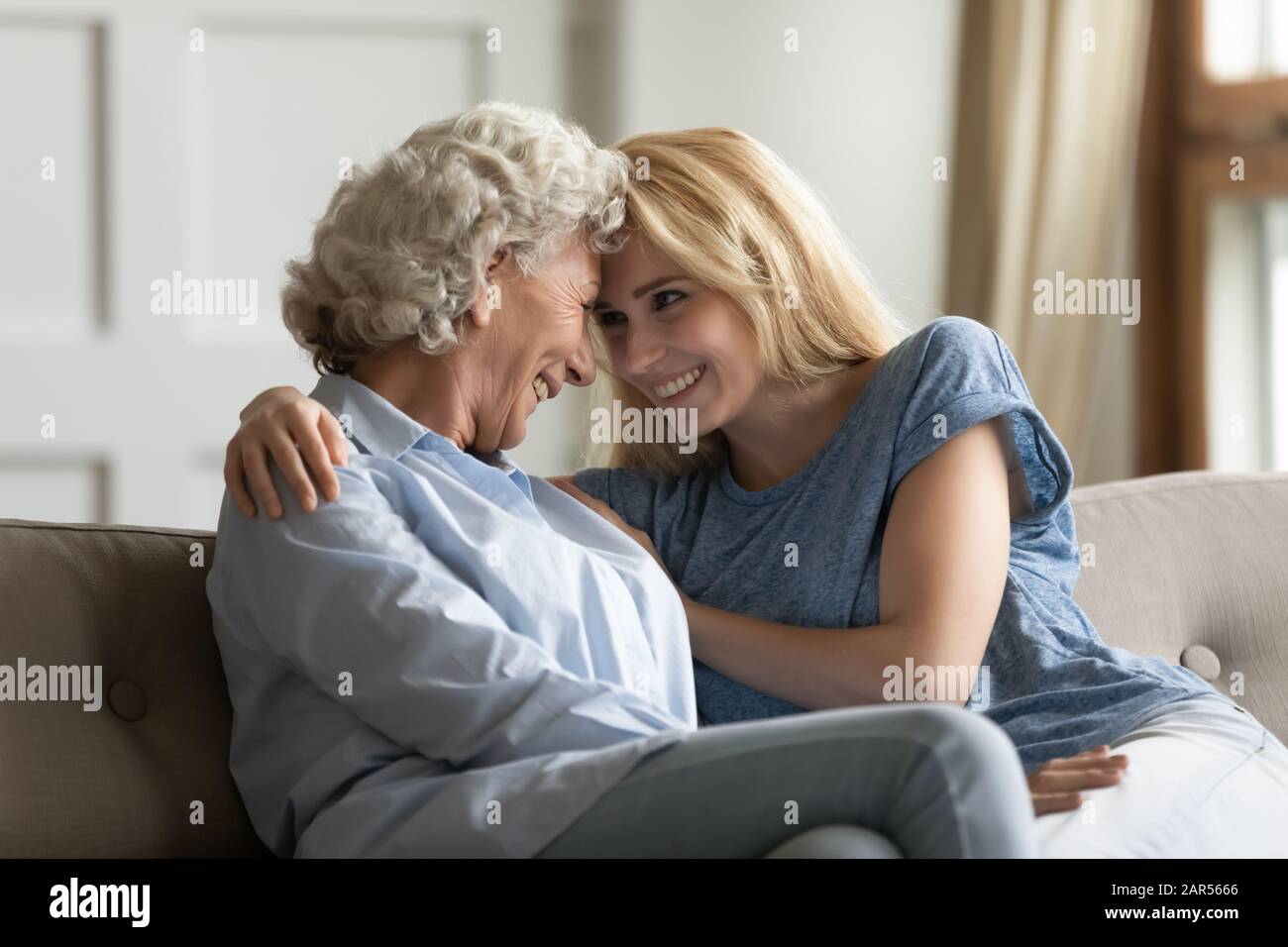 Loving young lady enjoying sweet tender moment with older mother. Stock Photo