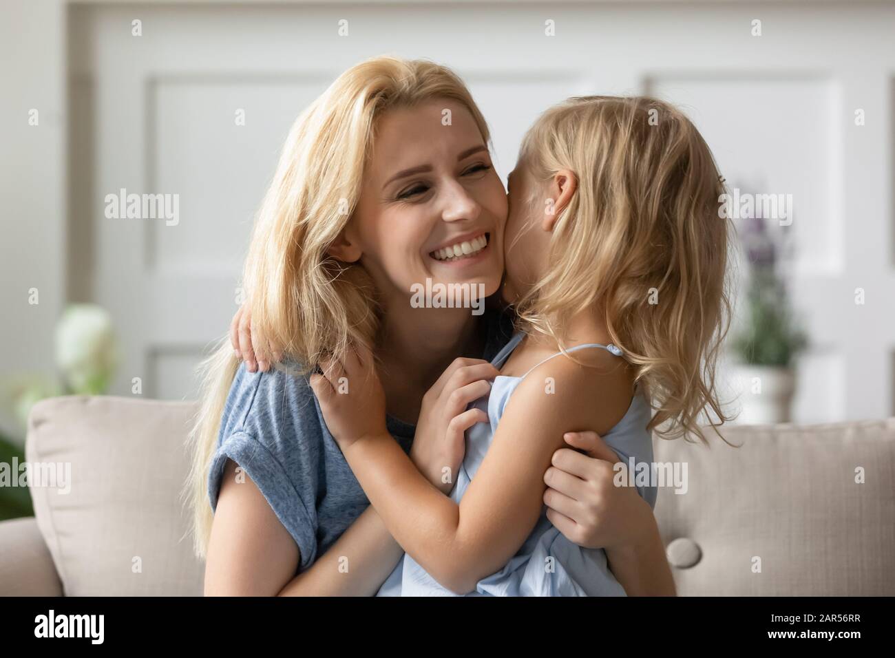 Joyful young mother playing with small daughter. Stock Photo