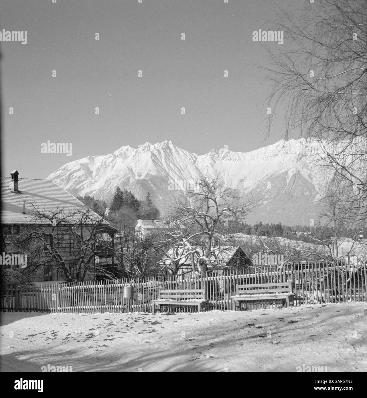 Winter in Tyrol  The Karwendel Mountains seen from a street in Sistrans Date: January 1960 Location: Austria, Sistrans, Tyrol Keywords: mountains, villages, landscapes, snow, winter, homes Stock Photo