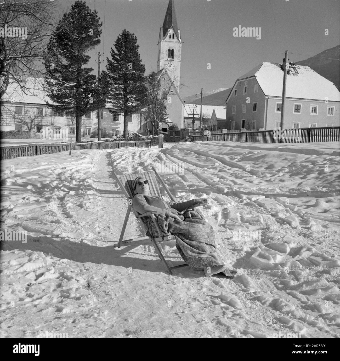Winter in Tyrol  Hilde Eschen is sunbathing in the snow Date: January 1960 Location: Austria, Sistrans, Tyrol Keywords: mountains, villages, snow, holiday, winter Personal name: Eschen, Hilde Stock Photo