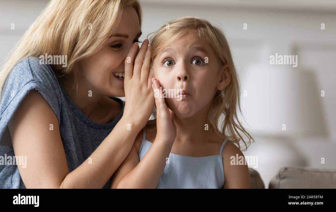 Close up surprised curious small kid listening to rumor. Stock Photo