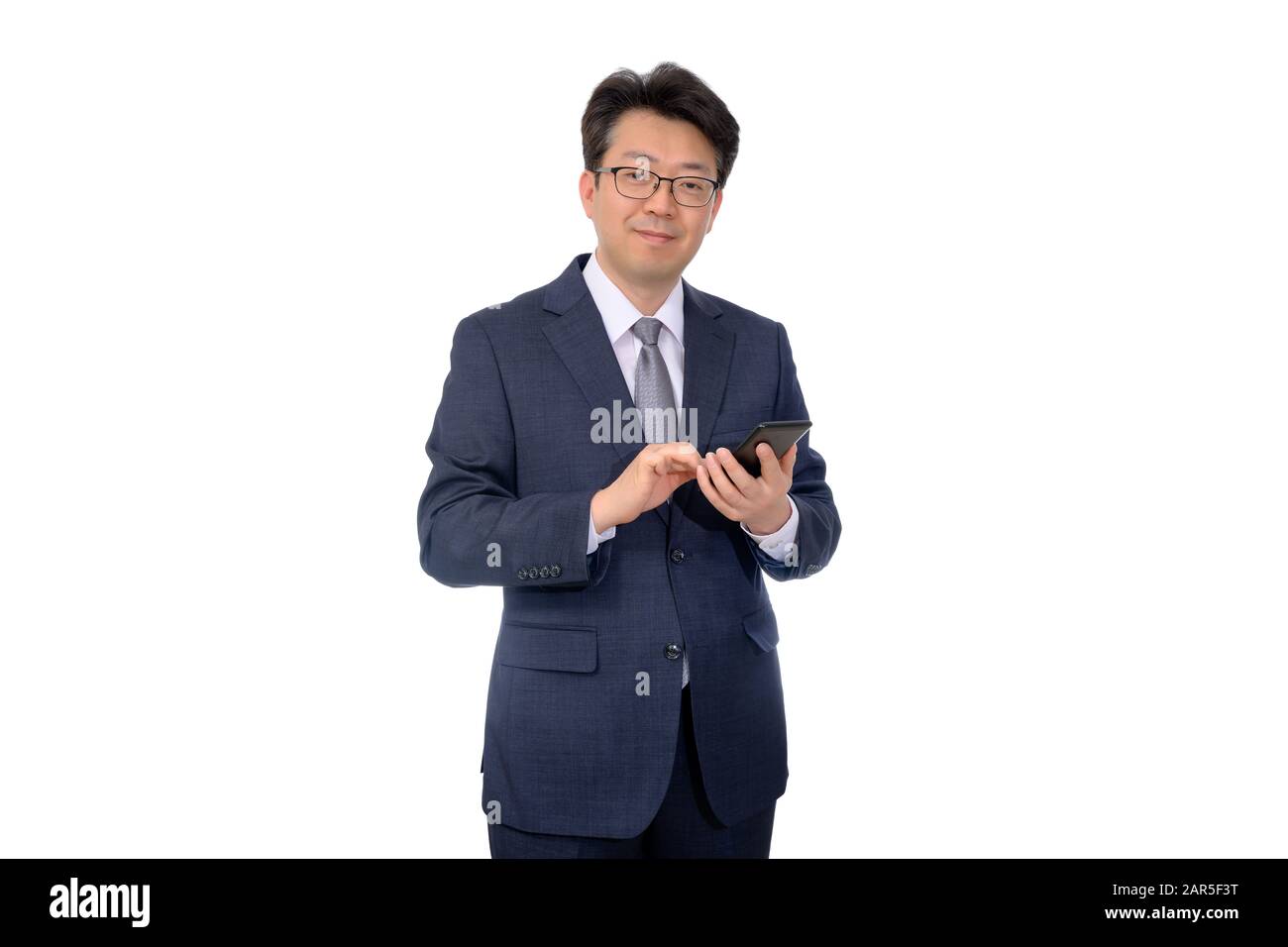 Asian middle-age businessman using a mobile smartphone on a white background. Stock Photo