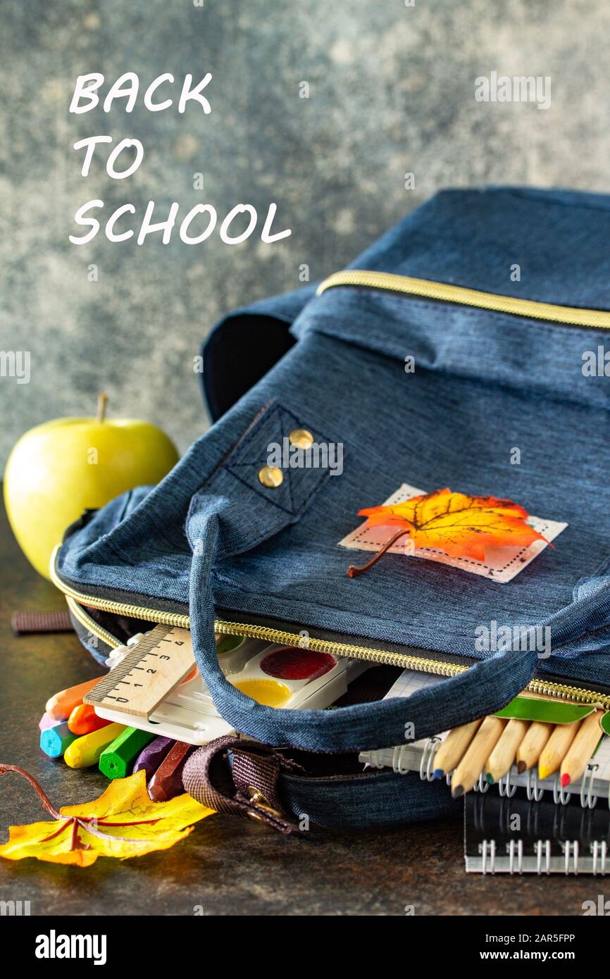 Back to school concept. School supplies with blue backpack on table. Stock Photo