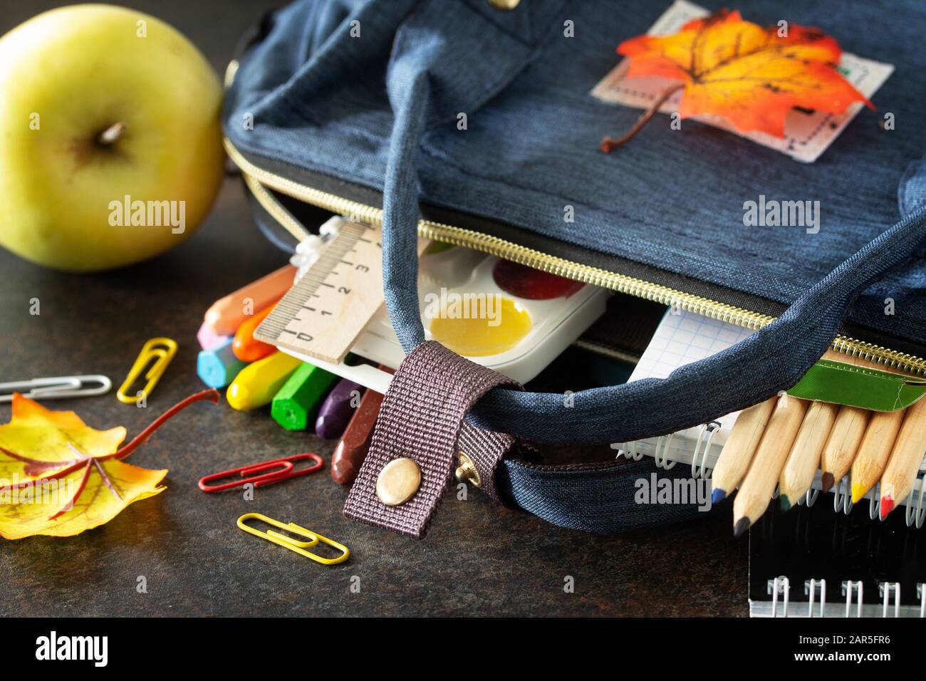 Back to school concept. School supplies with blue backpack on table. Stock Photo