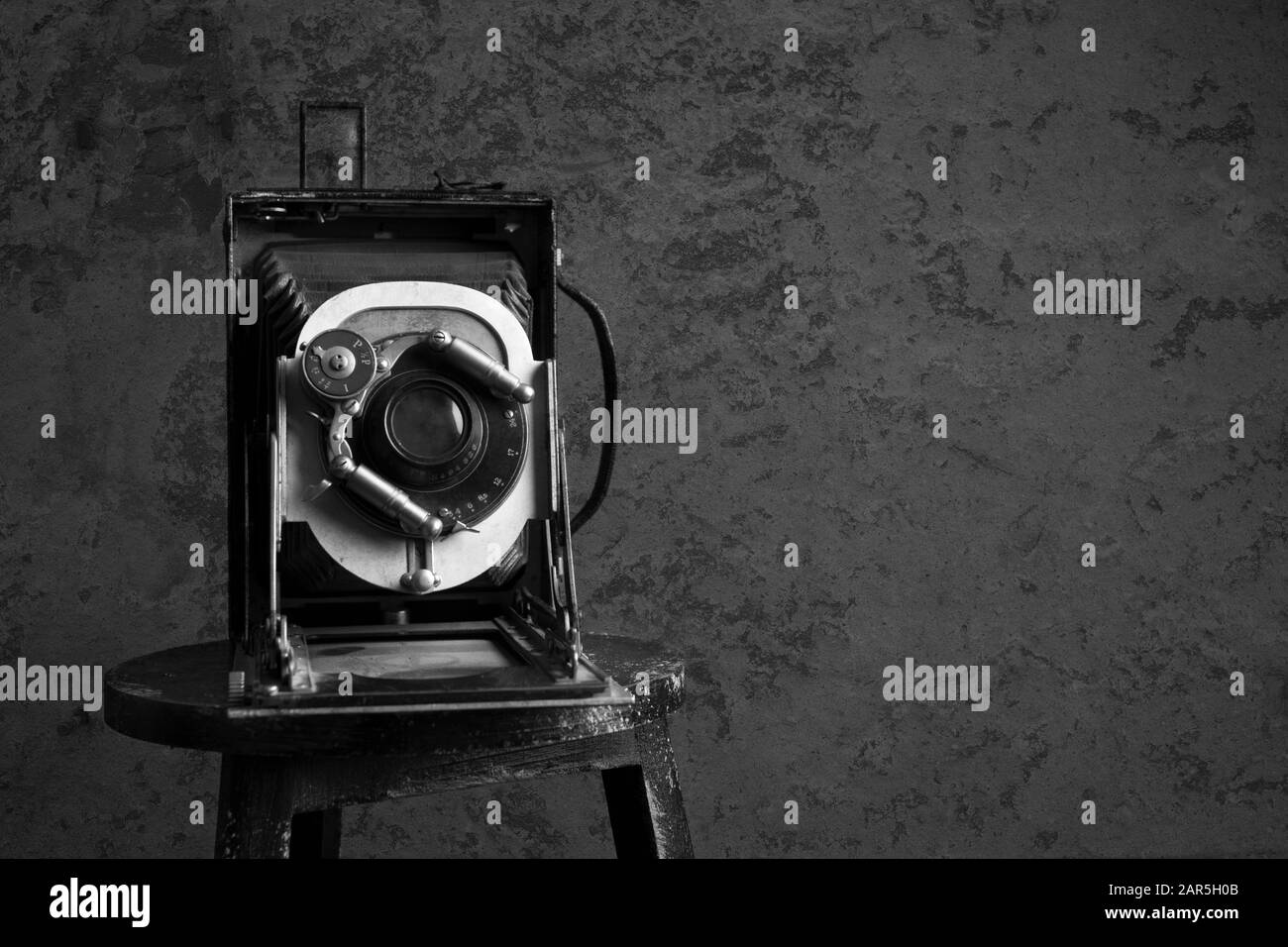 Antique camera on a old wall with copy space in a black and white grunge look Stock Photo
