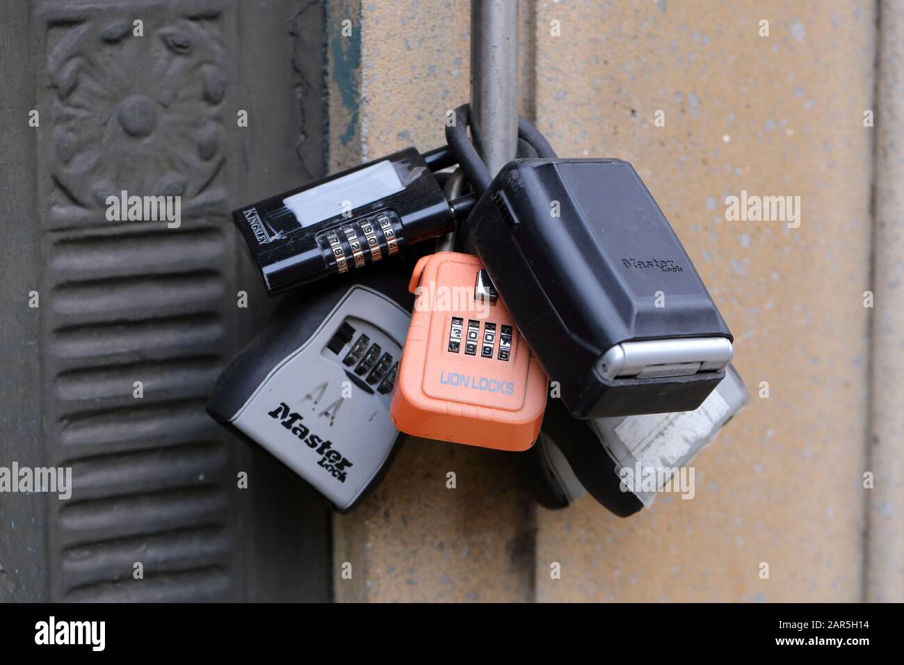 A myriad of couch surfing, and pet sitter lock boxes locked to a pole Stock Photo