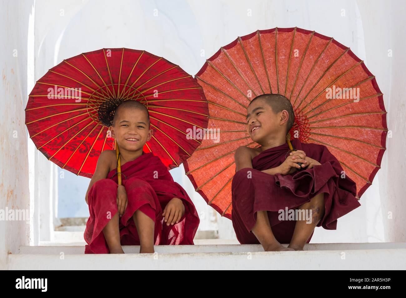 Young novice Buddhist monks holding parasols at Myatheindan Pagoda