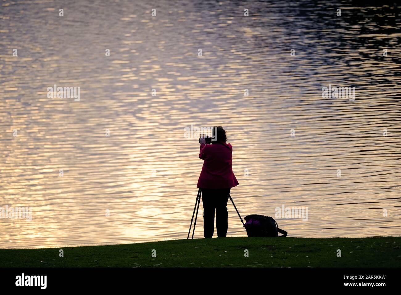Photographer taking a picture of Derwent Water in the Lake District at sunset. Stock Photo