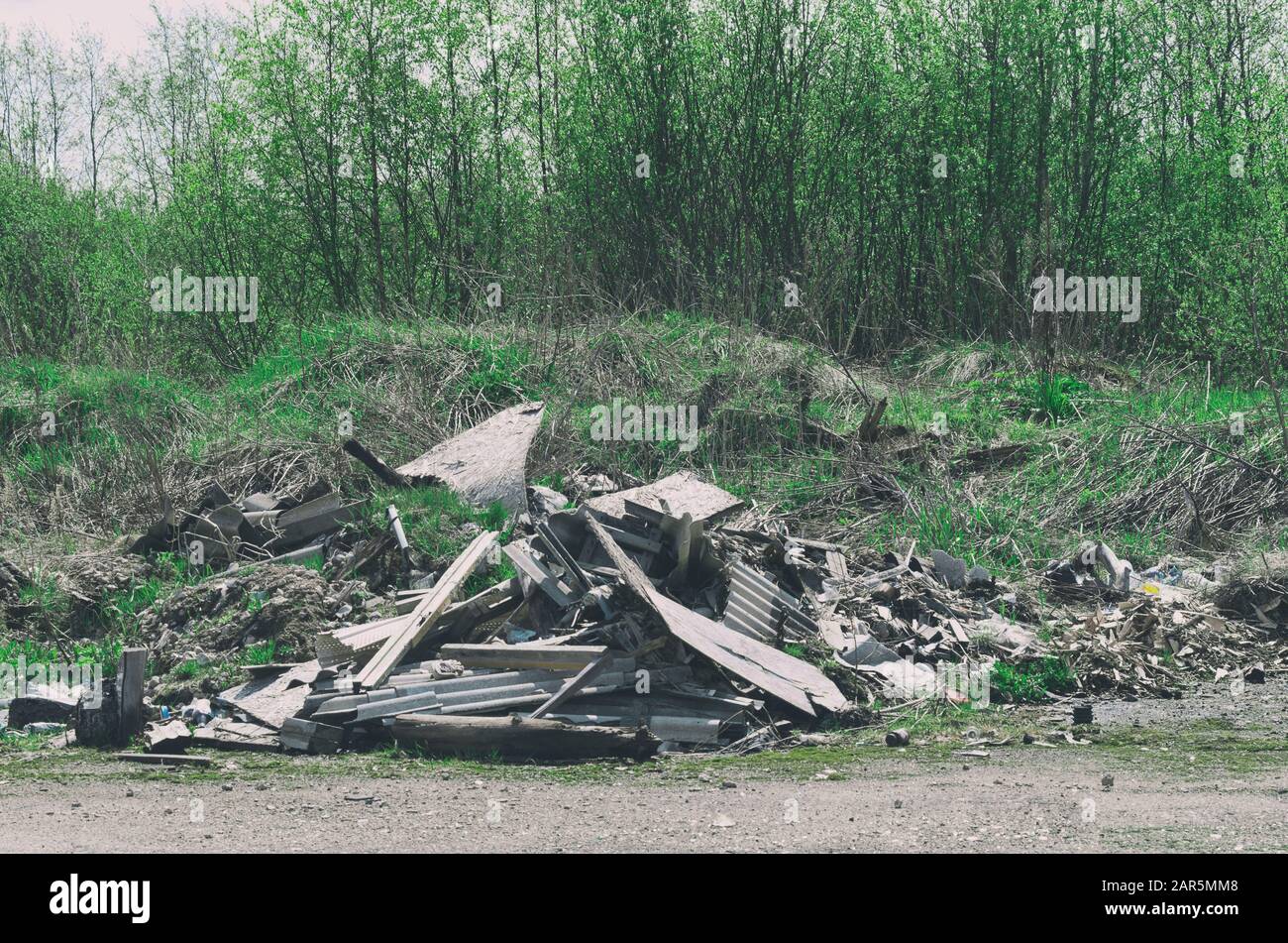 Pile of construction debris and waste near the spring young forest Stock Photo