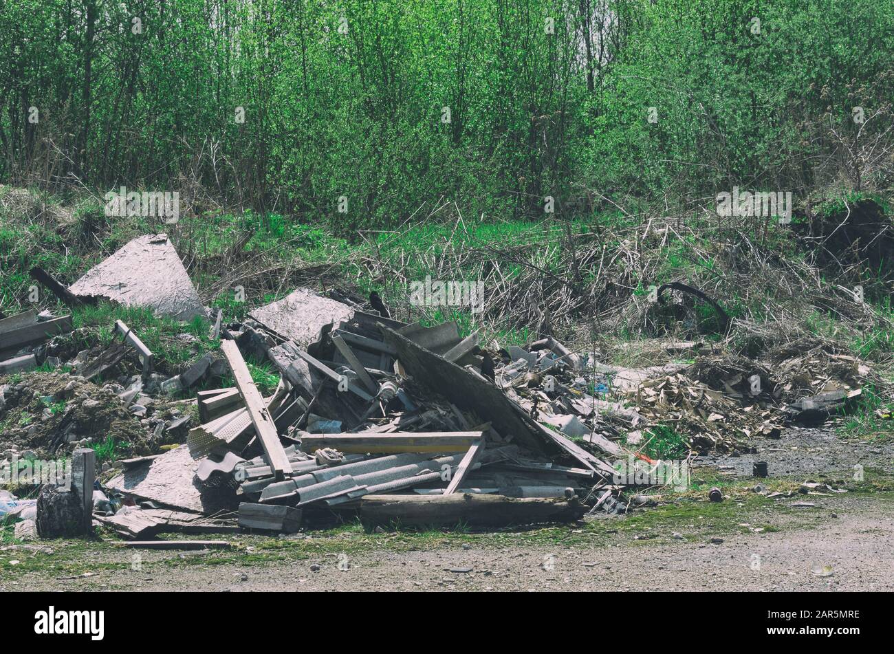 Pile of construction debris and waste near the spring young forest Stock Photo