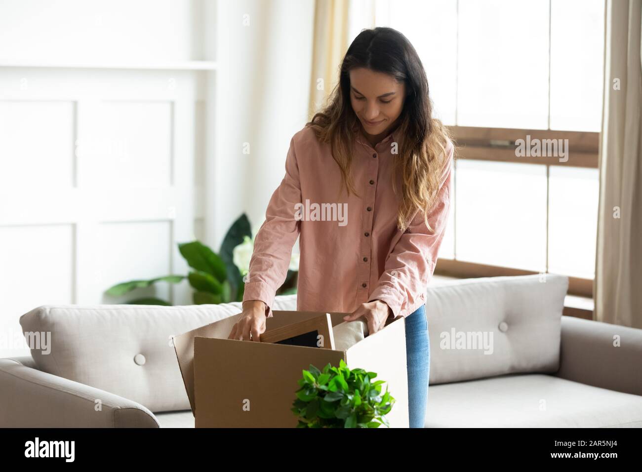 Caucasian young woman unpacking in new own home Stock Photo