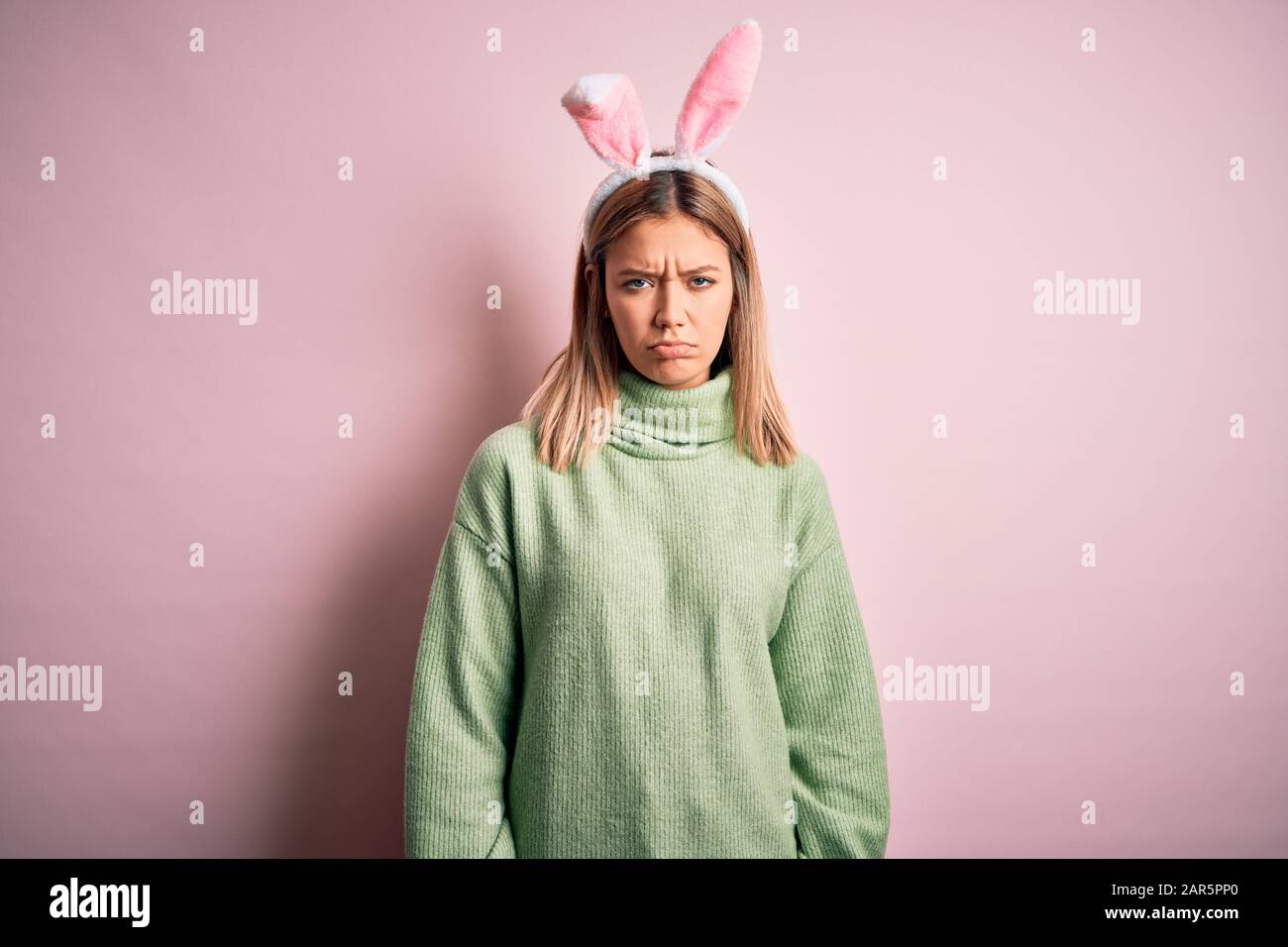 Young beautiful woman wearing easter rabbit ears standing over isolated ...