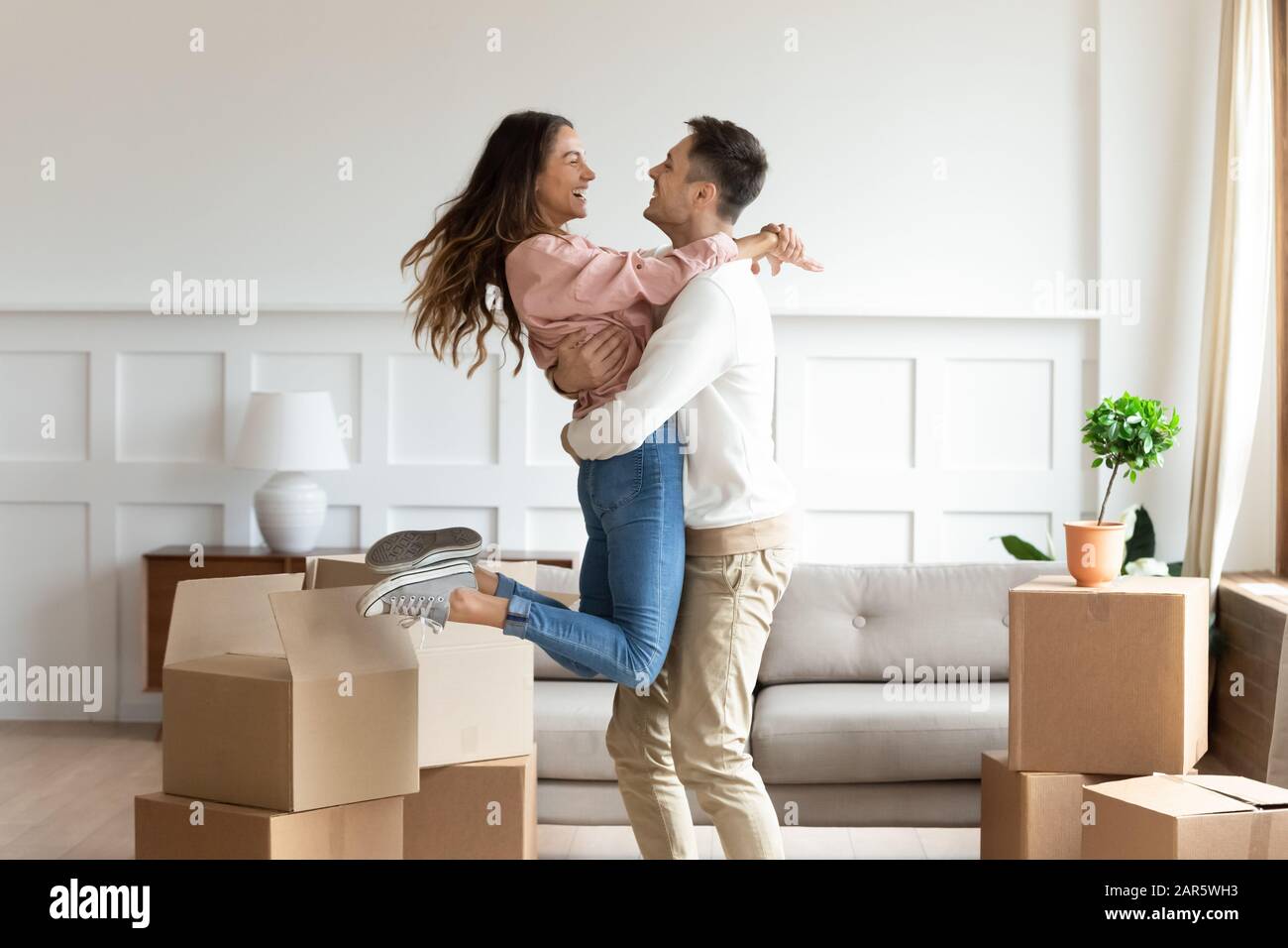 Overjoyed couple dancing excite to move in together Stock Photo