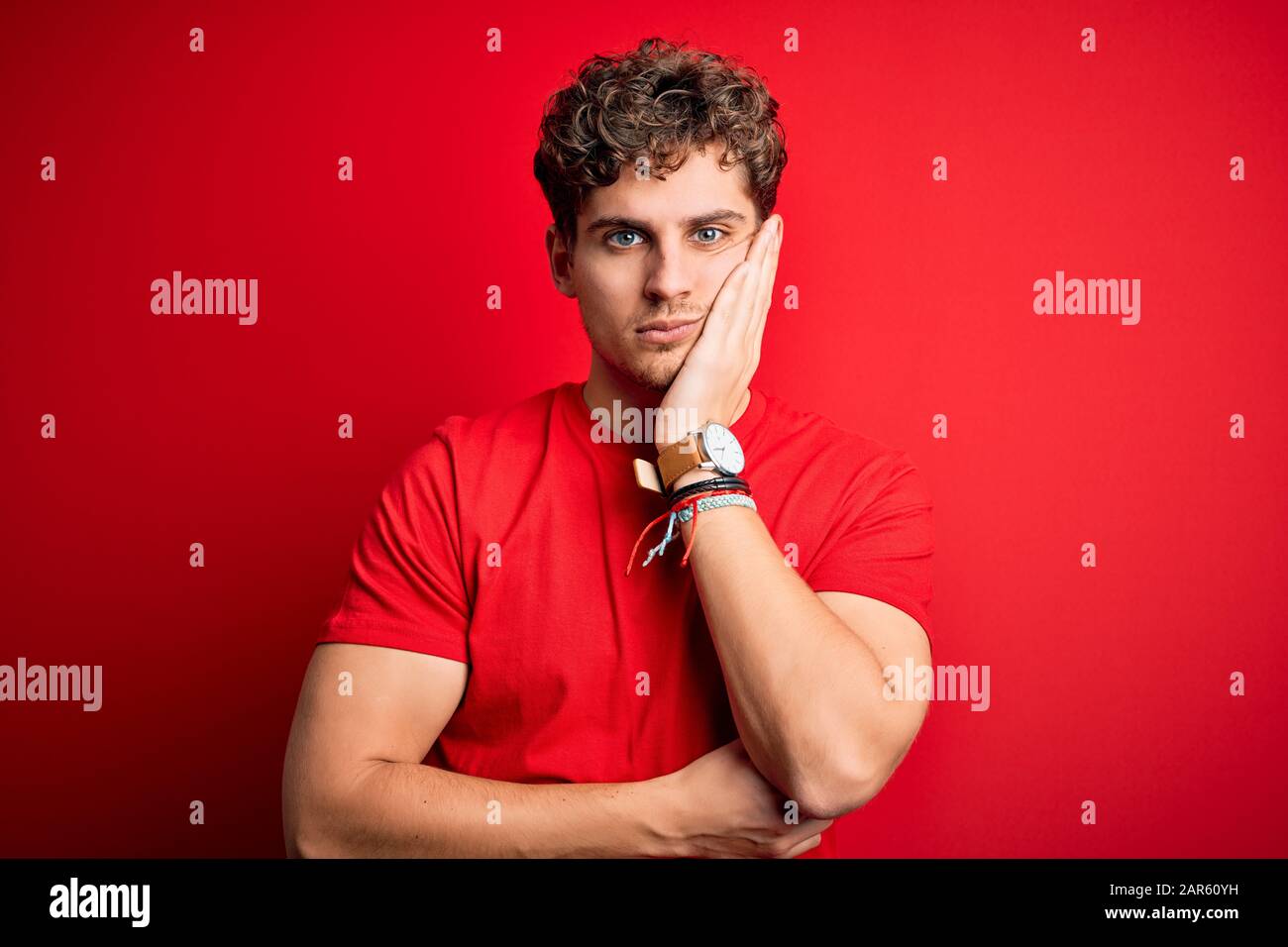 Young Blond Handsome Man With Curly Hair Wearing Casual T Shirt