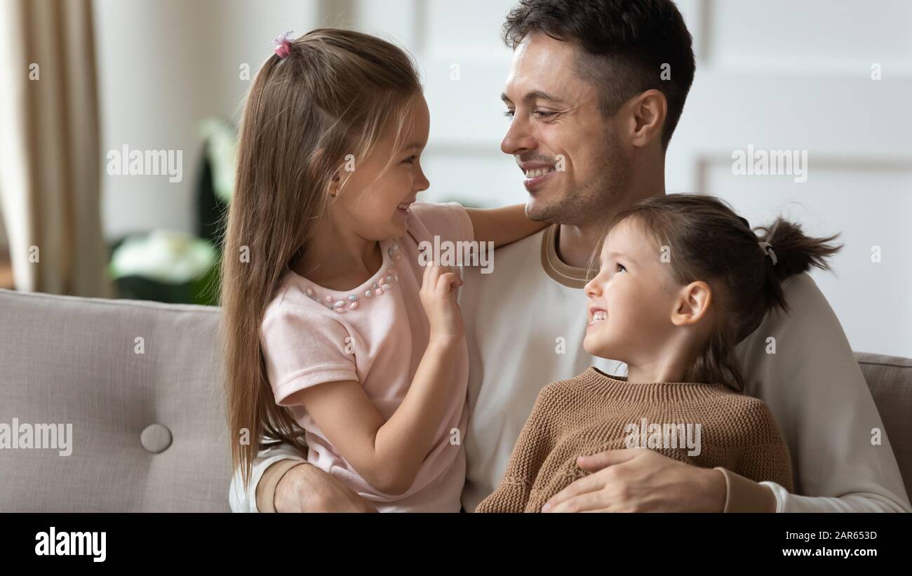 Loving dad play with little daughters at home Stock Photo