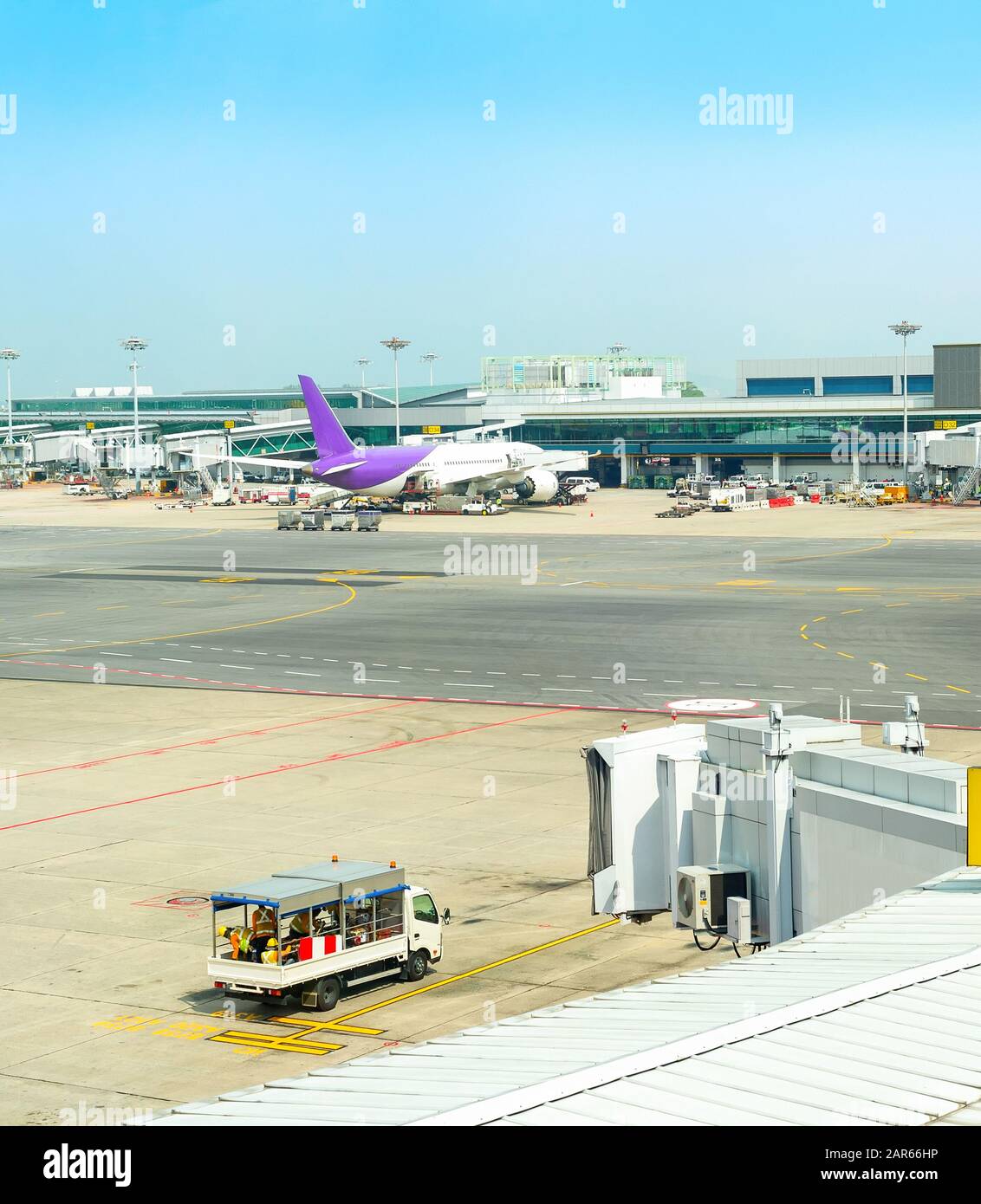 Airfield with planes, service equipment by Changi Airport building, Singapore Stock Photo