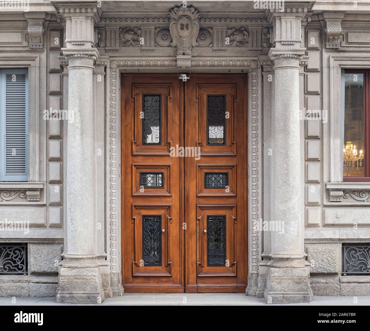 luxurious entrance door inserted between two columns, of a palace at number 31 on a street in Milan Stock Photo